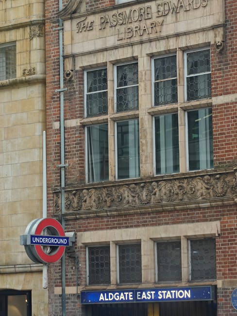 A wide view of a busy street in Liverpool Street, featuring multi-storey buildings with classic European architectural styles, including ornate facades and large windows. The street has a smooth aspha